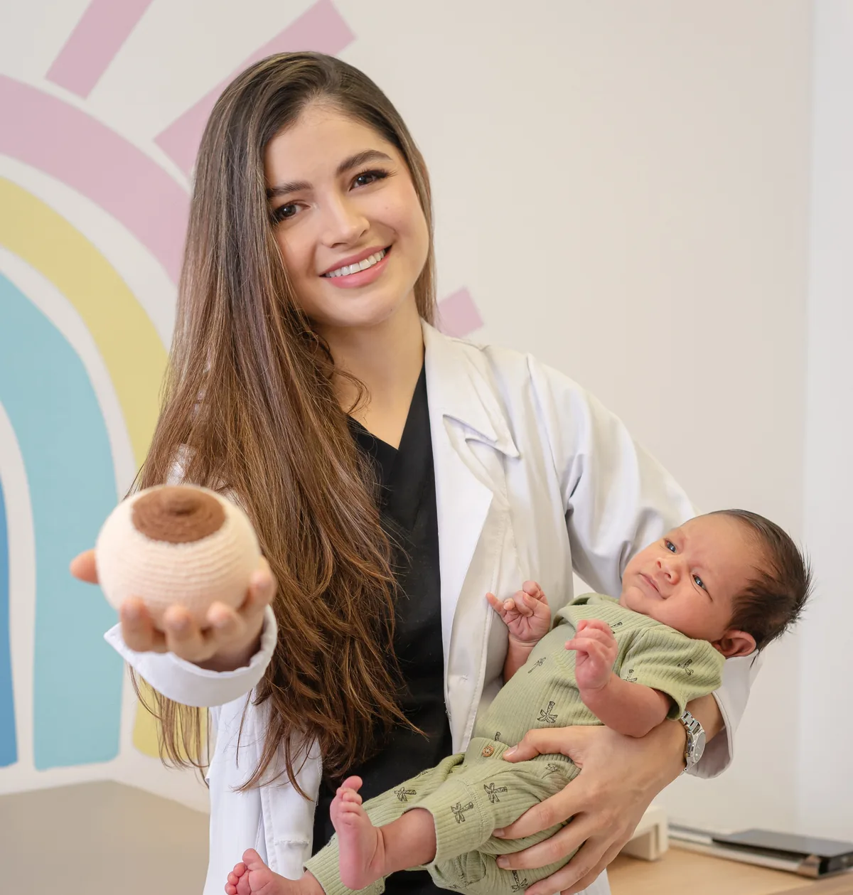 La Dra. Laura Mendoza con un bebé en brazos en la consulta